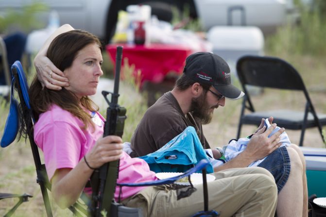 Chris Shelton of Las Vegas interacts with his 1-week-old son as his mother Shelley Shelton holds his rifle during a Bundy family "Patriot Party" near Bunkerville, Nevada, on April 18.