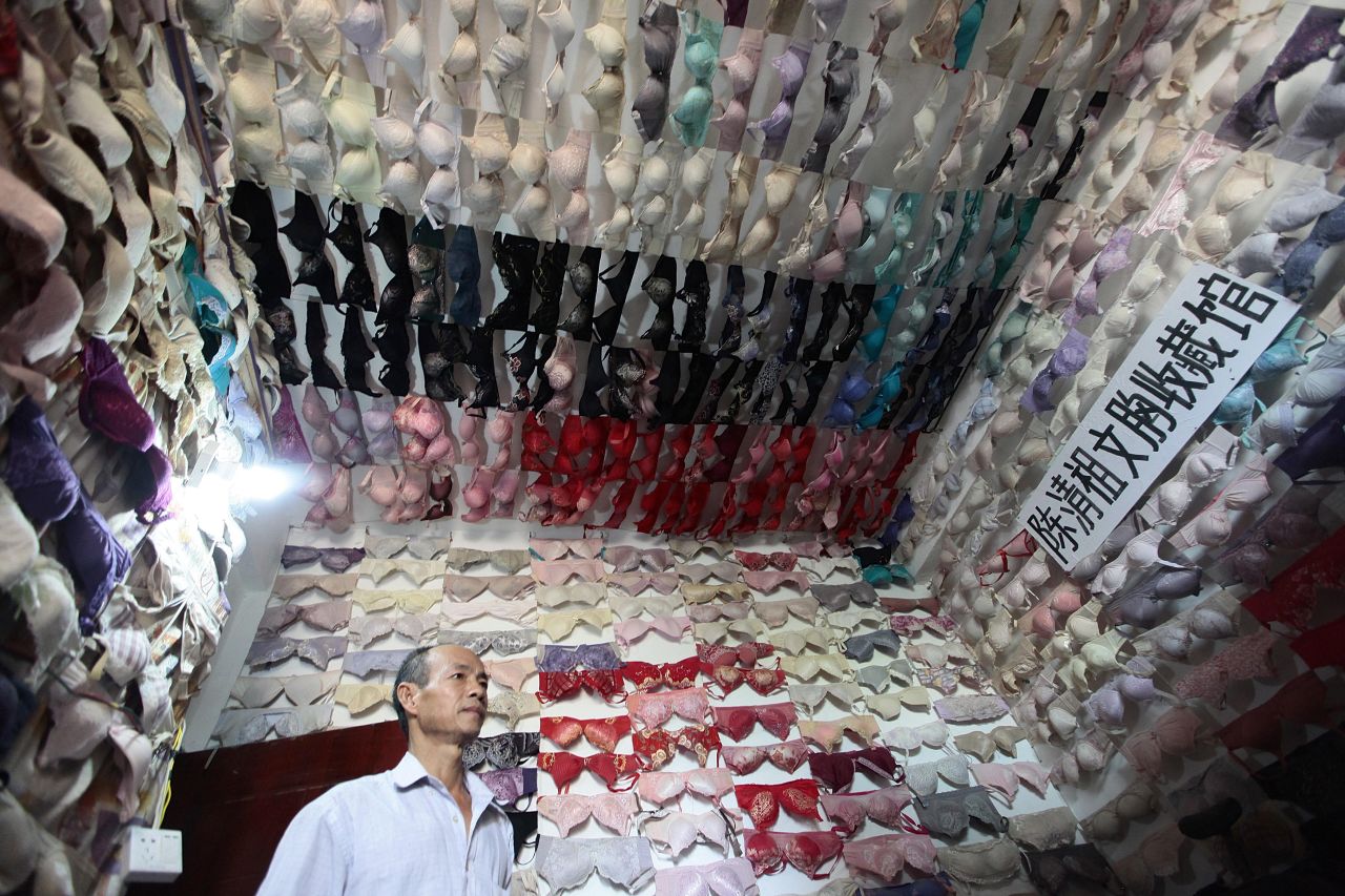 Chen Qingzu, 56, stands in a small room covered with his collection of bras in Sanya, China, on Tuesday, April 22. Chen has collected about 5,000 bras over 20 years after touring more than 30 colleges around the country for public benefit activities aiming to raise awareness of breast cancer.