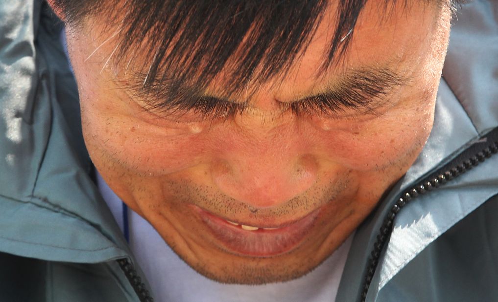 A relative of a passenger weeps while waiting for news of his missing loved one at a port in Jindo on April 25.