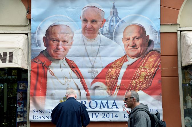Un afiche con los papas Juan Pablo II, Juan XXIII y Francisco.