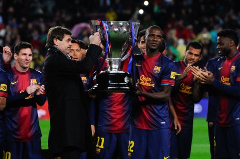 Vilanova and Eric Abidal, who had been diagnosed with a liver tumor, share the honors as they lift the trophy for Barca's 22nd league title.