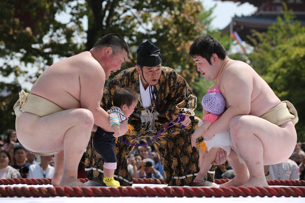 Two babies held by amateur sumo wrestlers go face to face in the crying contest.