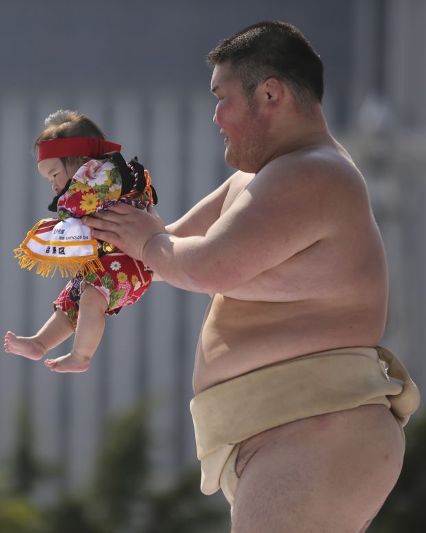 A sumo wrestler holds a colorful contestant. <em>Naki-zumo</em> is a tradition that goes back more than 400 years, according to <a href="http://www.japantimes.co.jp/culture/2012/05/04/events/babies-set-to-tear-up-the-ring/#.U1wjc8_D-Um" target="_blank" target="_blank">The Japan Times</a>.