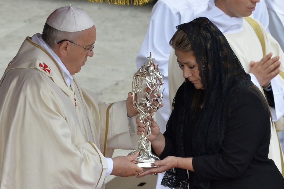 Floribeth Mora of Costa Rica, who claims she was cured of a serious brain condition by a miracle attributed to the late Pope John Paul II, hands the relic of John Paul II to Pope Francis during the canonization Mass for Popes John XXIII and John Paul II at the Vatican on Sunday, April 27.