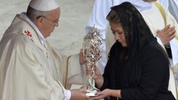 Floribeth Mora, of Costa Rica, who claims she was cured of a serious brain condition by a miracle attributed to late Pope John Paul II, hands the relic of John Paul II to Pope Francis during the canonisation mass of Popes John XXIII and John Paul II on St Peter's at the Vatican on April 27.