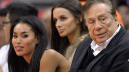 Los Angeles Clippers owner Donald Sterling, right, and V. Stiviano, left, watch the Clippers play the Sacramento Kings during the first half of an NBA basketball game in Los Angeles, on October 25, 2013.