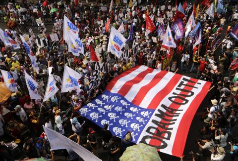 Protesters carry a mock U.S. flag and shout anti-U.S. slogans during a protest of President Obama's visit to the Philippines on April 28.