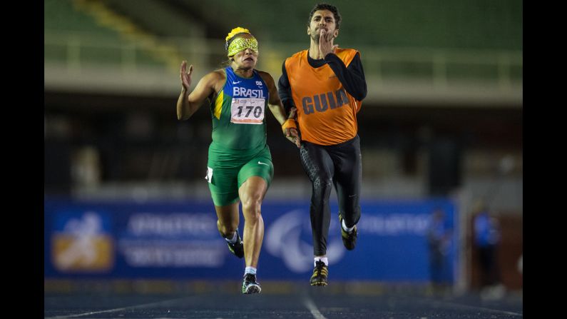 Sprinter Terezinha Guilhermina competes in the 200 meters along with her guide, Guilherme Santana, during the T11 final of the Loterias Caixa Brazilian Athletics Open Championships on Thursday, April 24. The T11 category is for athletes who are visually impaired.