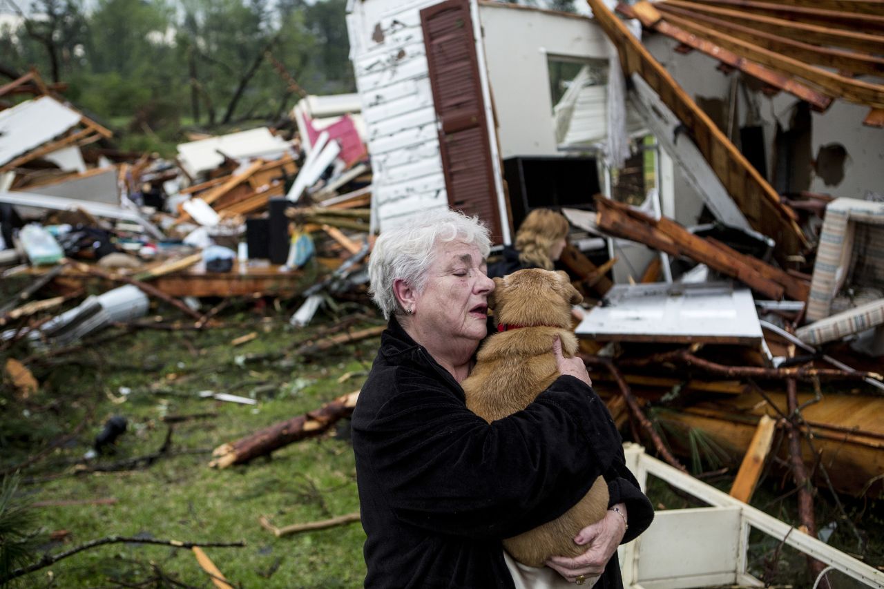 Constance Lambert embraces her dog after finding it when she returned to her destroyed home in Tupelo on Monday, April 28.