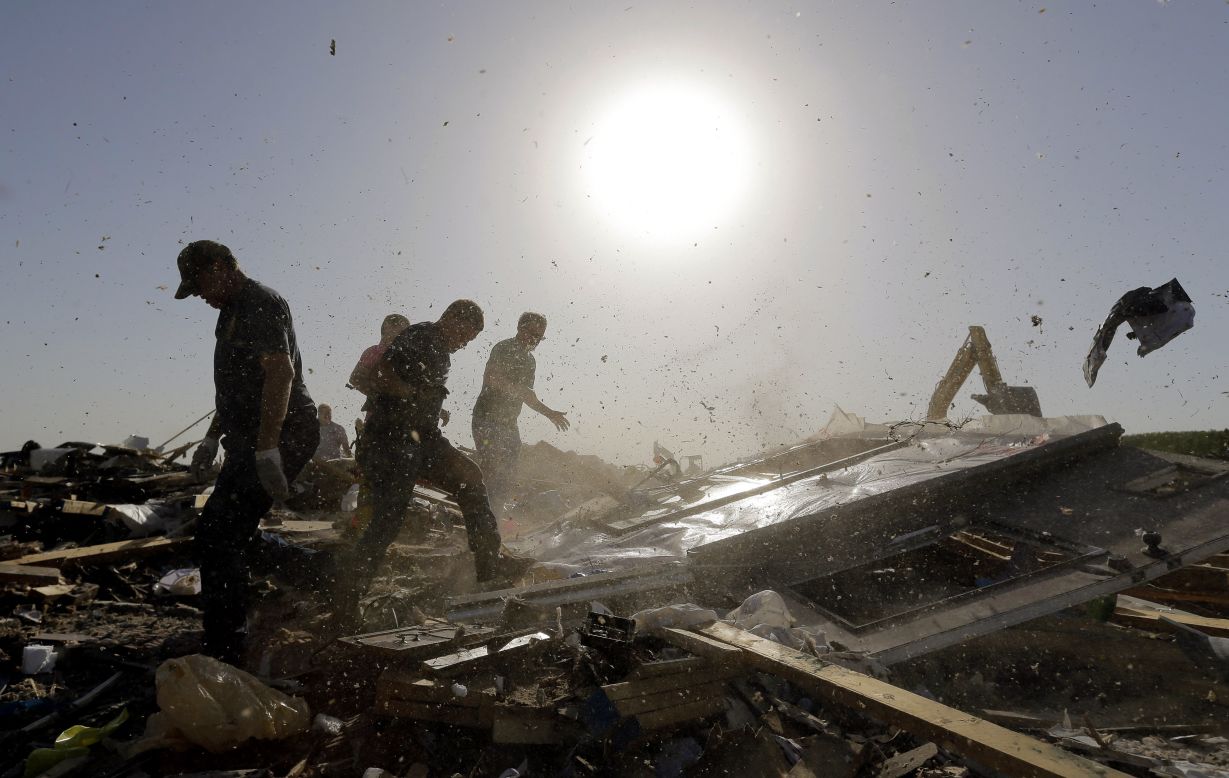 Dust and debris fly as workers flip a fallen wall while searching destroyed homes in Vilonia on April 28. Arkansas Gov. Mike Beebe said the storm was one of the worst to hit the state in recent memory.