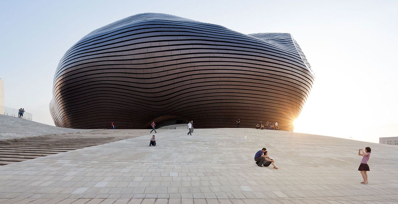 The Ordos Museum in Inner Mongolia designed by MAD Architects. The futuristic blob anchors the newly constructed desert city. It is covered in polished metal tiles that protect it from the frequent sandstorms. 
