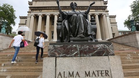 People walk past the Alma Mater statue on the Columbia University campus in New York City.