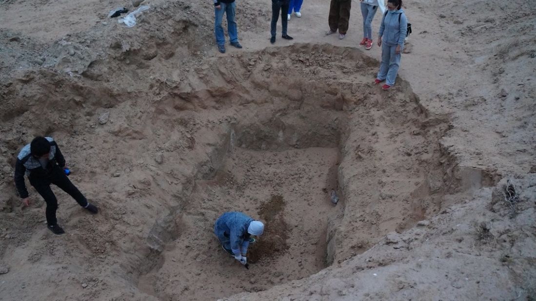 A group attempts to dig into a pit where up to 100 stray dogs were seen trapped earlier. Volunteers at the Yinchuan Stray Animals Home suspect someone filled the pit with soil, burying the dogs alive.