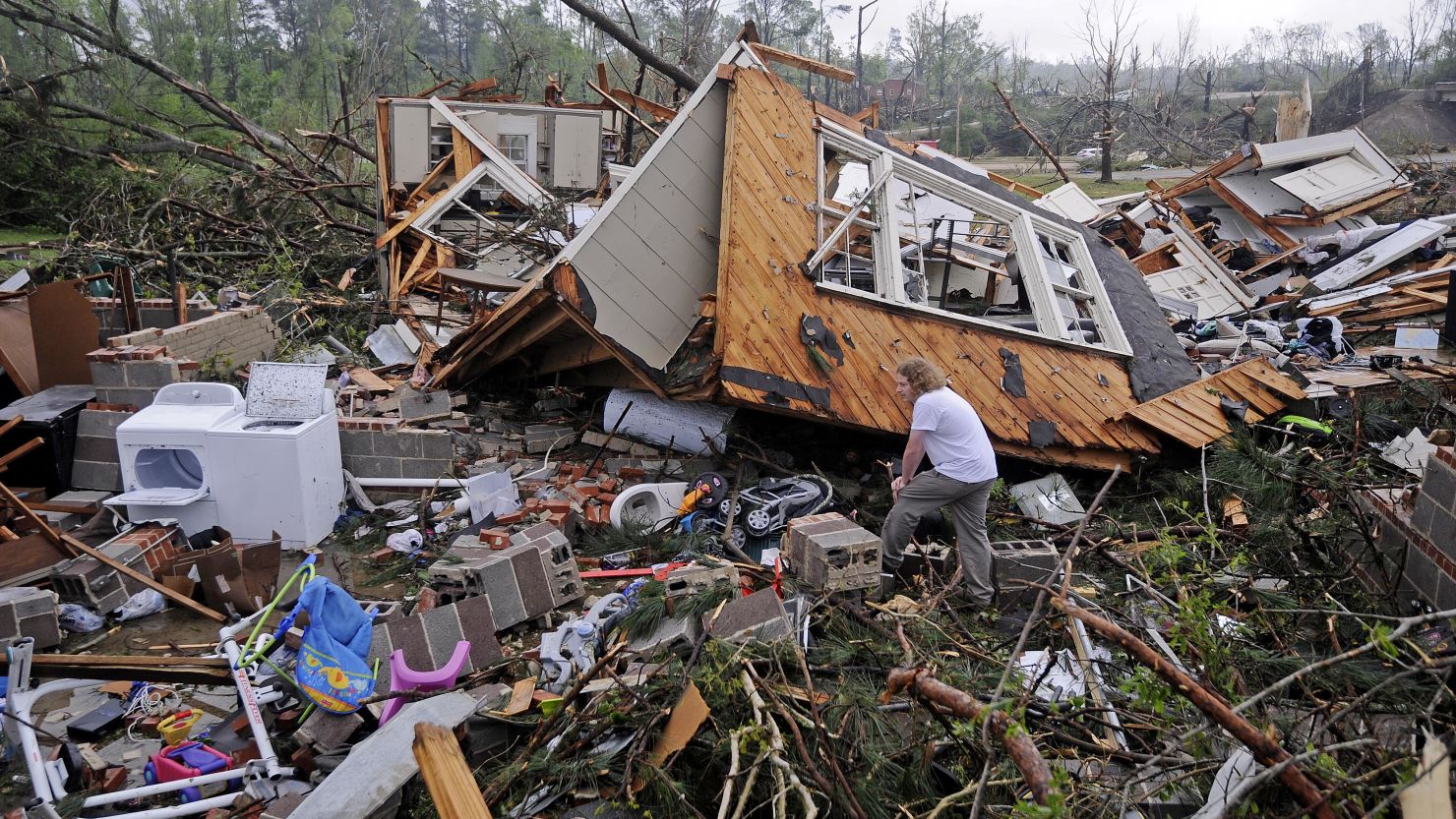 Kevin Barnes searches the remains of his home on Clayton Avenue in Tupelo, Miss., Tuesday, April 29, 2014. A dangerous storm system that spawned a chain of deadly tornadoes over three days flattened homes and businesses, forced frightened residents in more than half a dozen states to take cover and left tens of thousands in the dark Tuesday. (AP Photo/Thomas Graning)