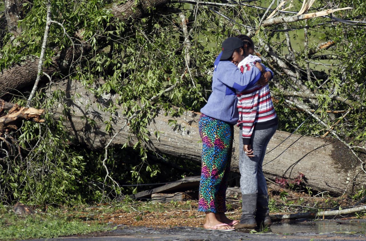 Carnesha Bennett, right, cries on a friend's shoulder after touring what remains of her mother's child care center in Louisville on April 29.