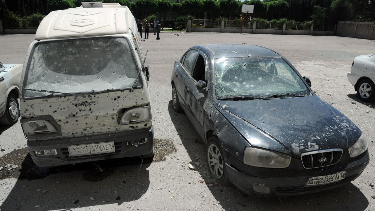 Shrapnel holes are visible on cars after a mortar attack Tuesday in the Syrian capital of Damascus.