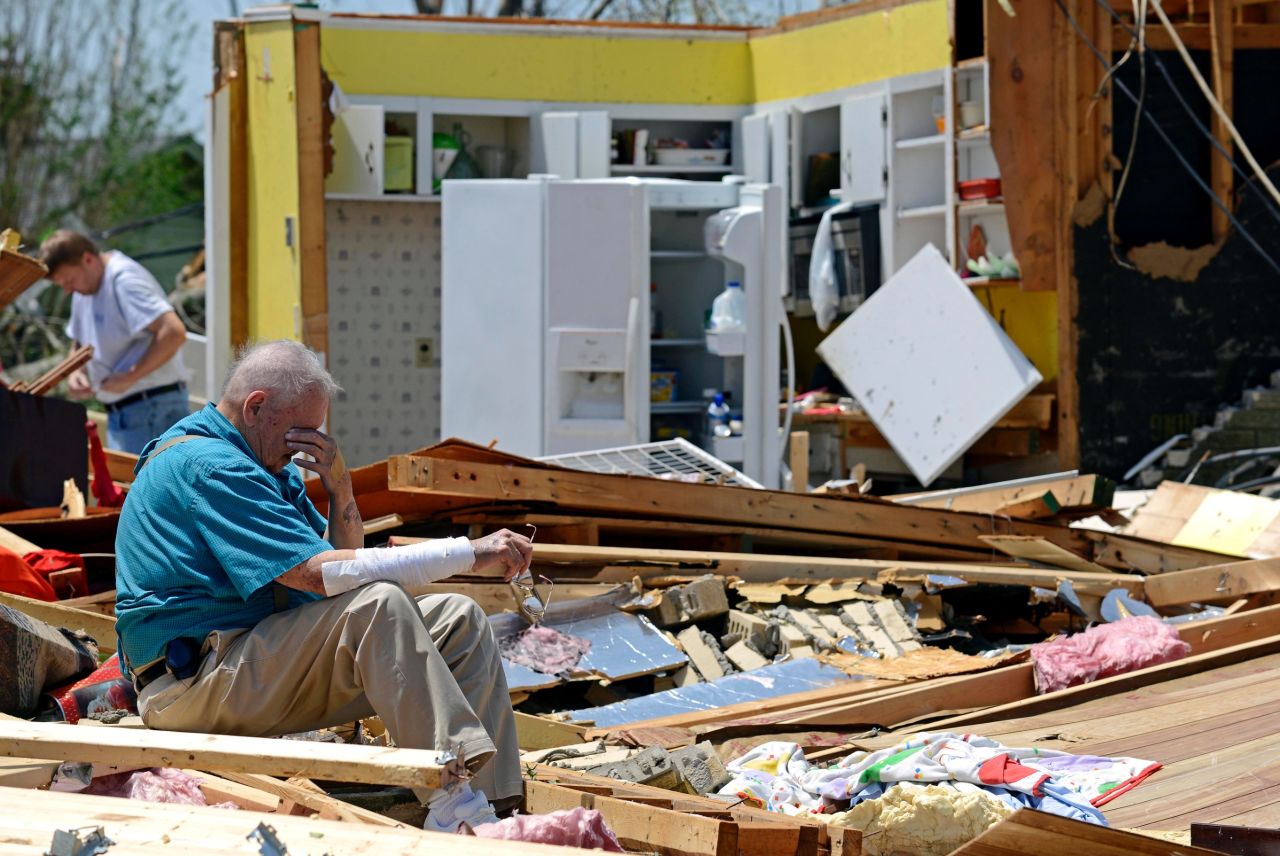 Charles Milam takes a break while searching his destroyed home in Tupelo on April 29.
