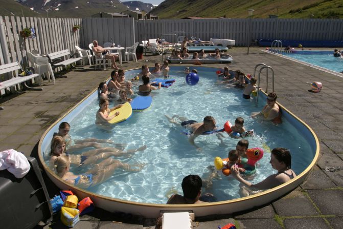 This geothermal pool features a mountainous backdrop. Bathers enjoy coffee and ice cream as they soak in one of two hot tubs.