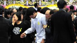 Students rescued from the sunken South Korean ferry 'Sewol', wearing white shirts, pay tribute at the state-controlled joint memorial altar for the dead in Ansan on April 30, 2014