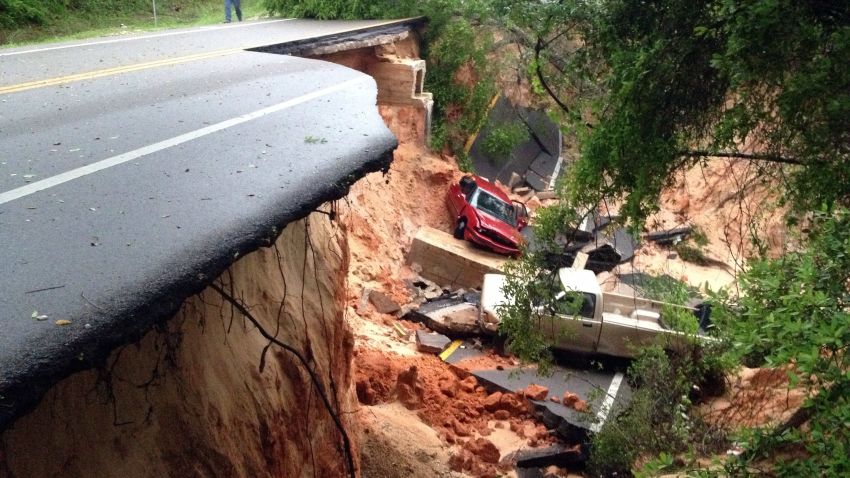 Vehicles rest at the bottom of a ravine after the Scenic Highway collapsed near Pensacola, Fla., Wednesday April 30, 2014. Heavy rains and flooding have left people stranded in houses and cars in the Florida Panhandle and along the Alabama coast. According to the National Weather Service, an estimated 15-20 inches of rain has fallen in Pensacola in the past 24 hours. (AP Photo/Pensacola News Journal, Katie E. King)