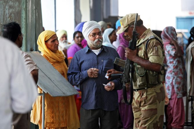 A soldier helps voters locate their polling station in the village of Sultanwind, near Amritsar, India, on April 30.