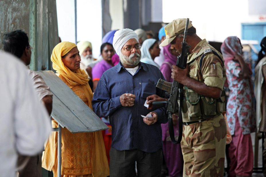 A soldier helps voters locate their polling station in the village of Sultanwind, near Amritsar, India, on April 30. 