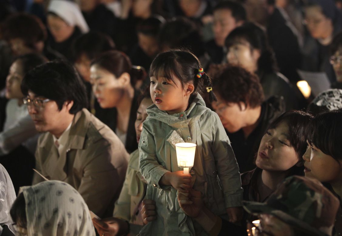 A girl in Seoul holds a candle during a service paying tribute to the victims of the Sewol on Wednesday, April 30. 