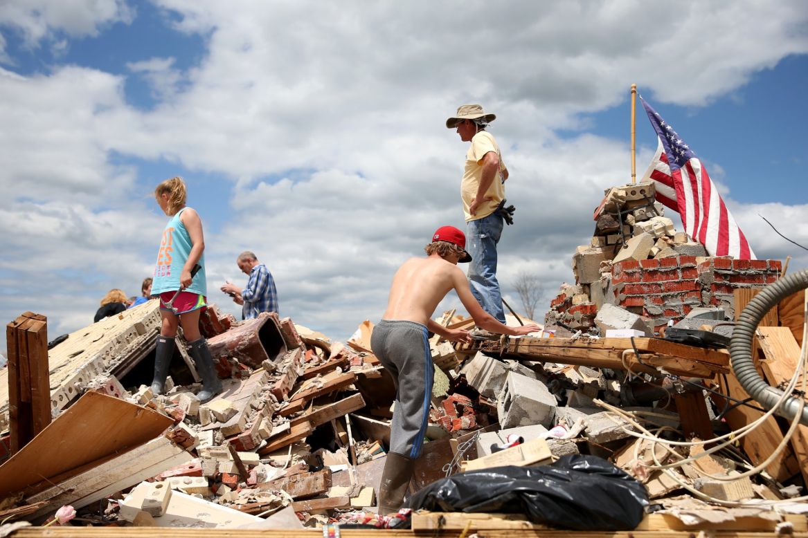 People look for items to salvage from a relative's tornado-ravaged home in Louisville, Mississippi, on Wednesday, April 30. 