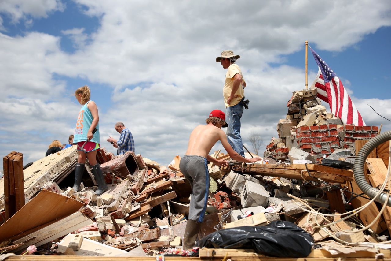 People look for items to salvage from a relative's tornado-ravaged home in Louisville, Mississippi, on Wednesday, April 30.