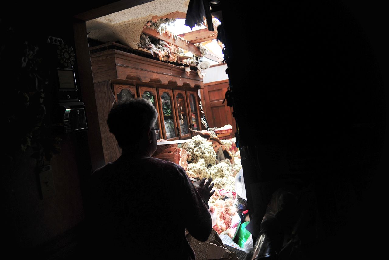 Faye Busby shows where a tornado ripped off part of her home's roof in Graysville, Alabama, on Tuesday, April 29.
