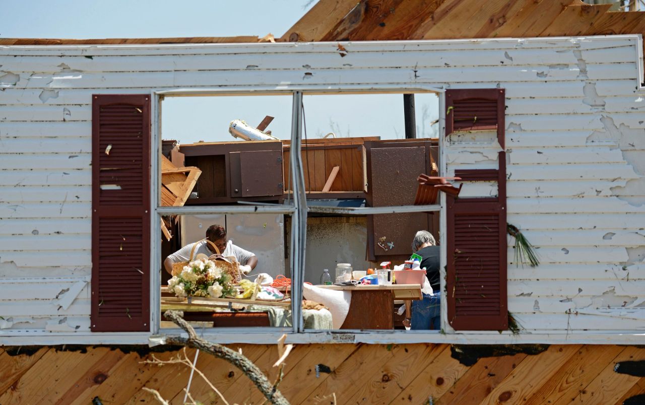 Bobbi Leggon and Sudie Carter work to salvage items from a friend's home in Tupelo on April 29.