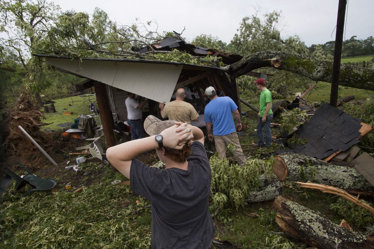 People work to clear a tree off a shed after a storm in Smiths Station, Alabama, on April 29.