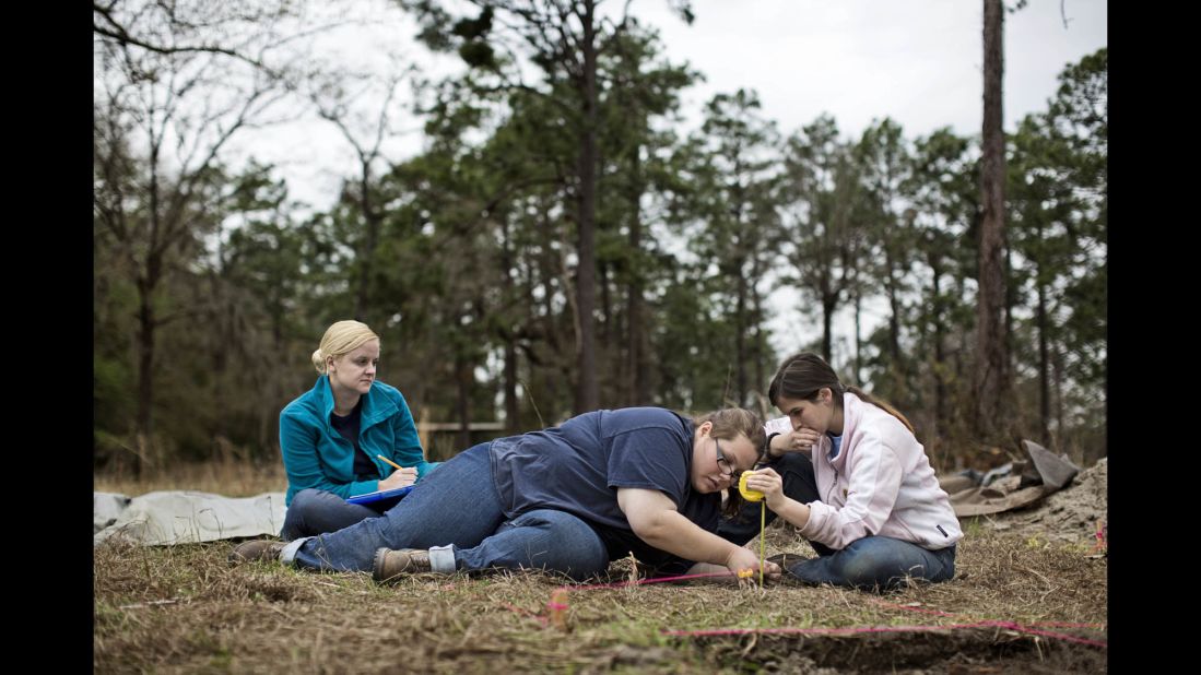 From left, Georgia Southern students Amanda Andreu, Amanda Shively, and Kylie Jones measure an excavation site in the part of the prison where about 10,000 Union soldiers were held captive during the Civil War.  Jones said this semester was her first field school, at which she learned proper archeological techniques. "It makes the past more real," she says of the effort.