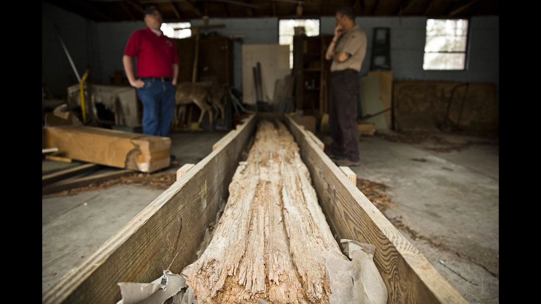 A massive timber log rests on the site of a now-closed hatchery where prisoners once lived. The log is believed to be one of the few remaining pieces of the original stockade wall, which encompassed a 1-mile perimeter around the prison. Kevin Chapman, left, a former Georgia Southern student who did extensive research at Lawton, and archeologist Rick Kanaski work for the U.S. Fish and Wildlife Service, which operates hatcheries. Part of Camp Lawton was built on property now belonging to the federal government.