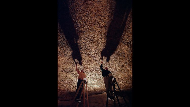 Marengo Cave visitors have tossed coins toward Penny Ceiling, where they get stuck in its soft, claylike surface. Every few years, staffers remove them, shown here.