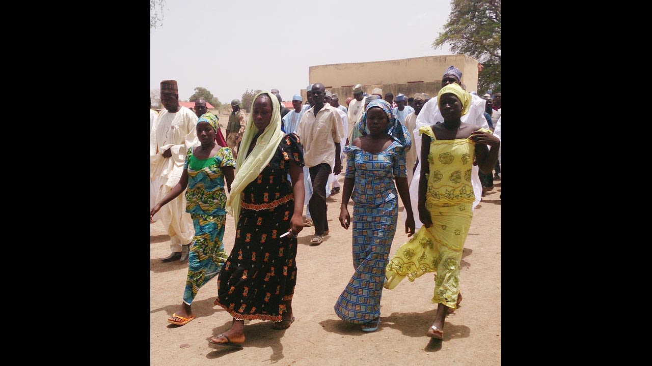 Four female students who were abducted by gunmen and reunited with their families walk in Chibok on Monday, April 21.