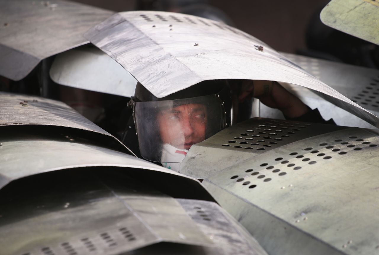 Police take cover under shields as pro-Russian activists storm the prosecutor's office in Donetsk on Thursday, May 1. Eastern Ukraine was a heartland of support for President Viktor Yanukovych, who was ousted in February.