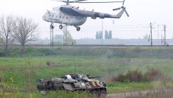 A helicopter lands near a tank at a checkpoint seized in the early morning in the village of Andreevka, 7 km from the center of the southern Ukrainian city of Slavyansk, on May 2, 2014. 
