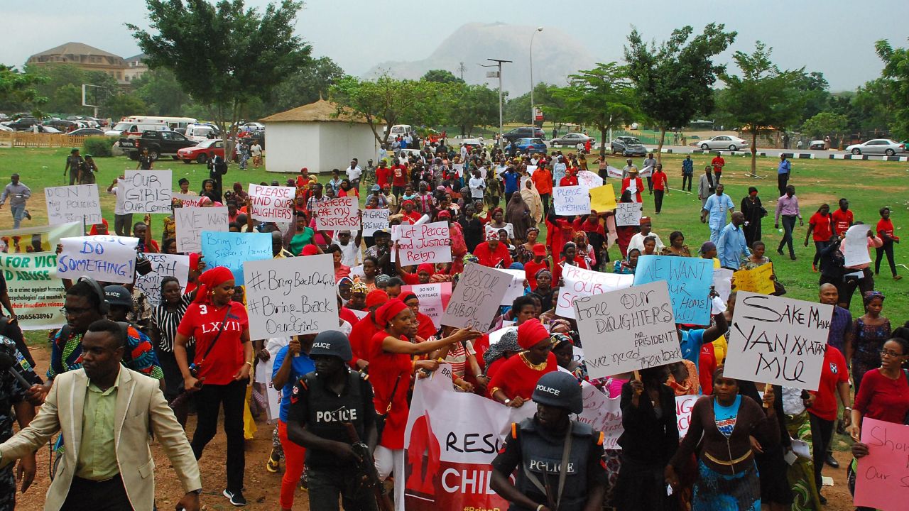 Former Nigerian Education Minister and Vice-President of the World Bank's Africa division (2nd L) Obiageli Ezekwesilieze speaks as she leads a march of Nigeria women and mothers of the kidnapped girls of Chibok, calling for their freedom in Abuja on April 30, 2014. Nigerian protesters marched on parliament today to demand the government and military do more to rescue scores of schoolgirls kidnapped by Boko Haram Islamists more than two weeks ago. Dubbed "a million woman march" and promoted on Twitter under #BringBackOurGirls, the protest was not expected to draw a massive crowd and turn-out was hindered by heavy rain in the capital Abuja. But several hundred women and men, mostly dressed in red, marched through the rain towards the National Assembly carrying placards that read "Find Our Daughters."