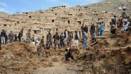 Afghan villagers search through dirt at the scene in the landslide-hit Aab Bareek village in Argo district of Badakhshan on May 5, 2014.