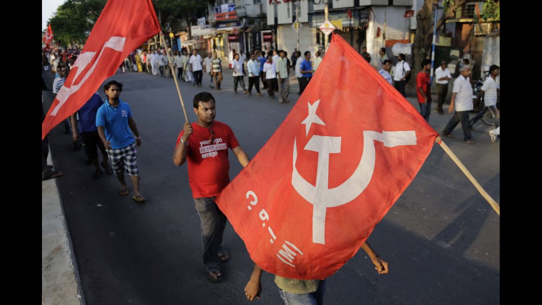 Supporters of the Communist Party of India (Marxist) walk with party flags during an election campaign in Kolkata on Sunday, May 4. 