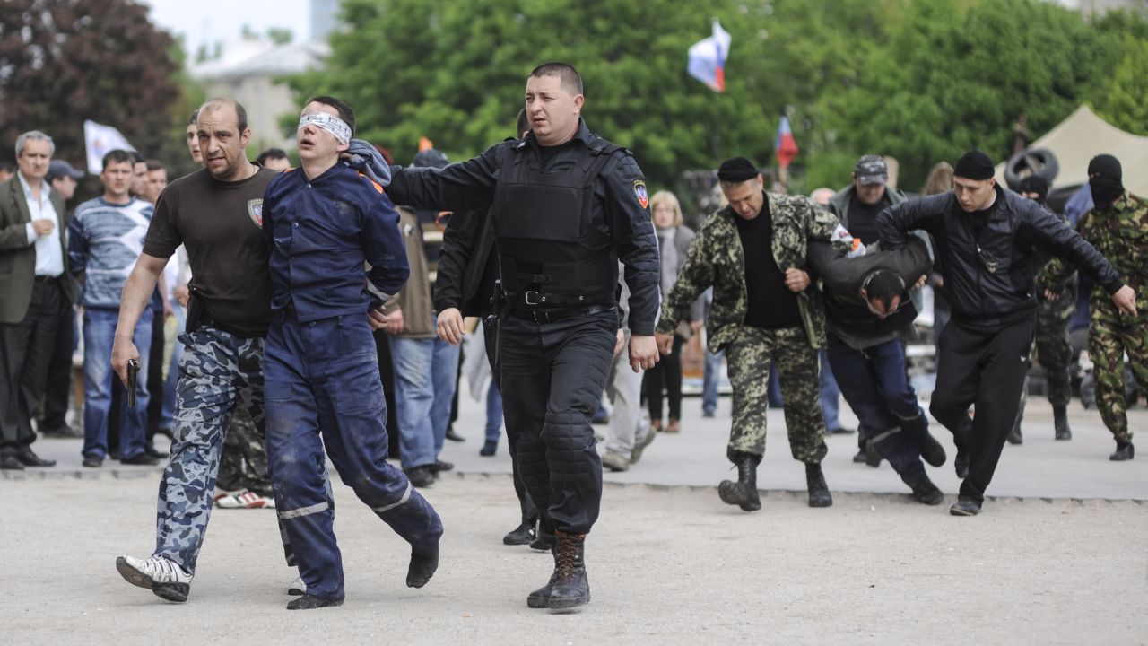 Pro-Russian supporters lead blindfolded men in front of the regional administration building in Donetsk on Monday, May 5.