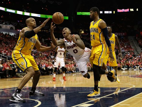 Atlanta point guard Jeff Teague, center, is fouled by Indiana's Paul George, right, during Game 6 of their NBA playoff series Thursday, May 1, in Atlanta. The Pacers, the No. 1 seed in the Eastern Conference, would go on to win the game and the series.
