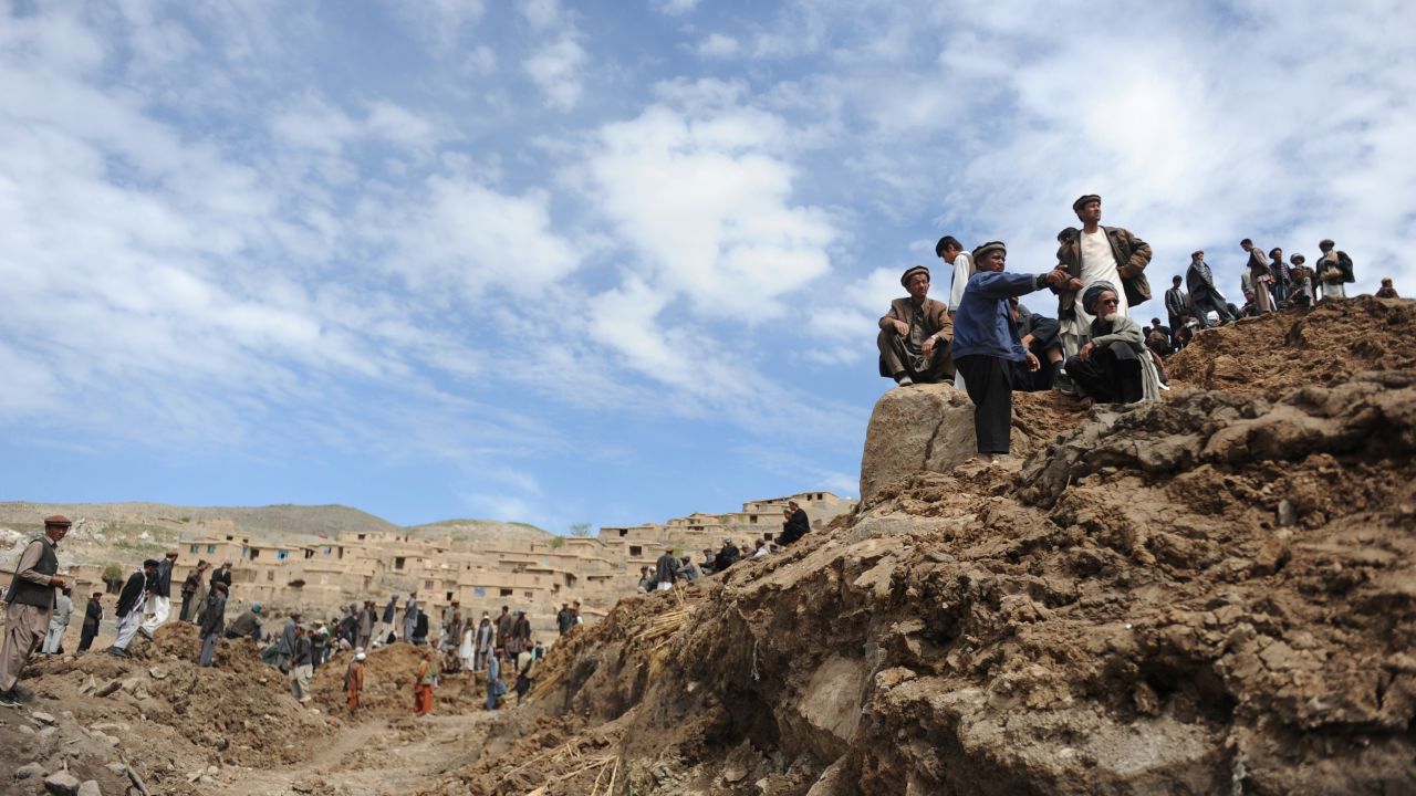 Afghan villagers search through dirt and debris at the scene of the landslide on May 5. 