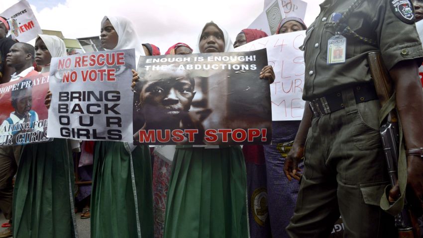 A policeman stand beside children holding as members of Lagos based civil society groups hold rally calling for the release of missing Chibok school girls at the state government house, in Lagos, Nigeria, on May 5, 2014. Boko Haram on Monday claimed the abduction of hundreds of schoolgirls in northern Nigeria that has triggered international outrage, threatening to sell them as "slaves". "I abducted your girls, " the Islamist group's leader Abubakar Shekau said in the 57-minute video obtained by AFP, referring to the 276 students kidnapped from their boarding school in Chibok, Borno state, three weeks ago.