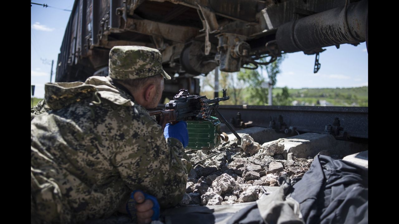 An armed pro-Russian separatist takes a position by the railway lines near Slovyansk on Tuesday, May 6.