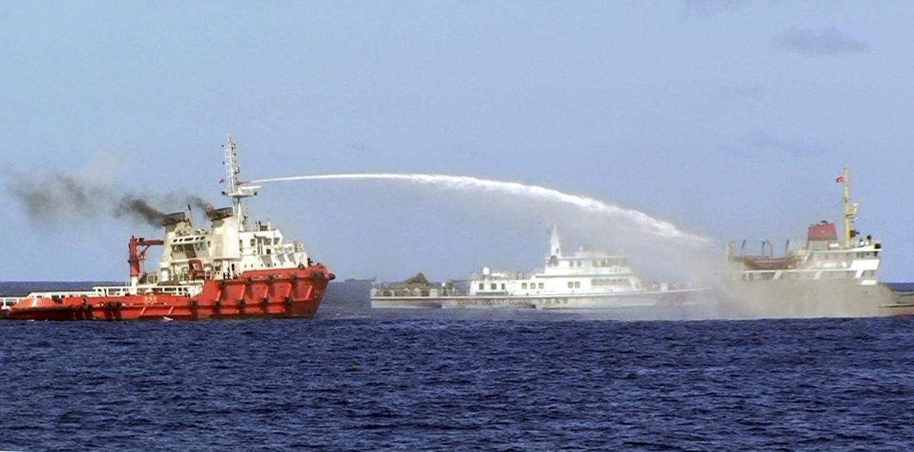 In this photo released by the Vietnam Coast Guard, a Chinese ship, left, shoots water cannon at a Vietnamese vessel, right, while a Chinese Coast Guard ship, center, sails alongside in the South China Sea, off Vietnam's coast, Wednesday, May 7, 2014.