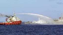 In this photo released by Vietnam Coast Guard, a Chinese ship, left, shoots water cannon at a Vietnamese vessel, right, while a Chinese Coast Guard ship, center, sails alongside in the South China Sea, off Vietnam's coast, Wednesday, May 7, 2014. Chinese ships are ramming and spraying water cannons at Vietnamese vessels trying to stop Beijing from setting up an oil rig in the South China Sea, according to Vietnamese officials and video evidence Wednesday, a dangerous escalation of tensions in disputed waters considered a global flashpoint. (AP Photo/Vietnam Coast Guard)