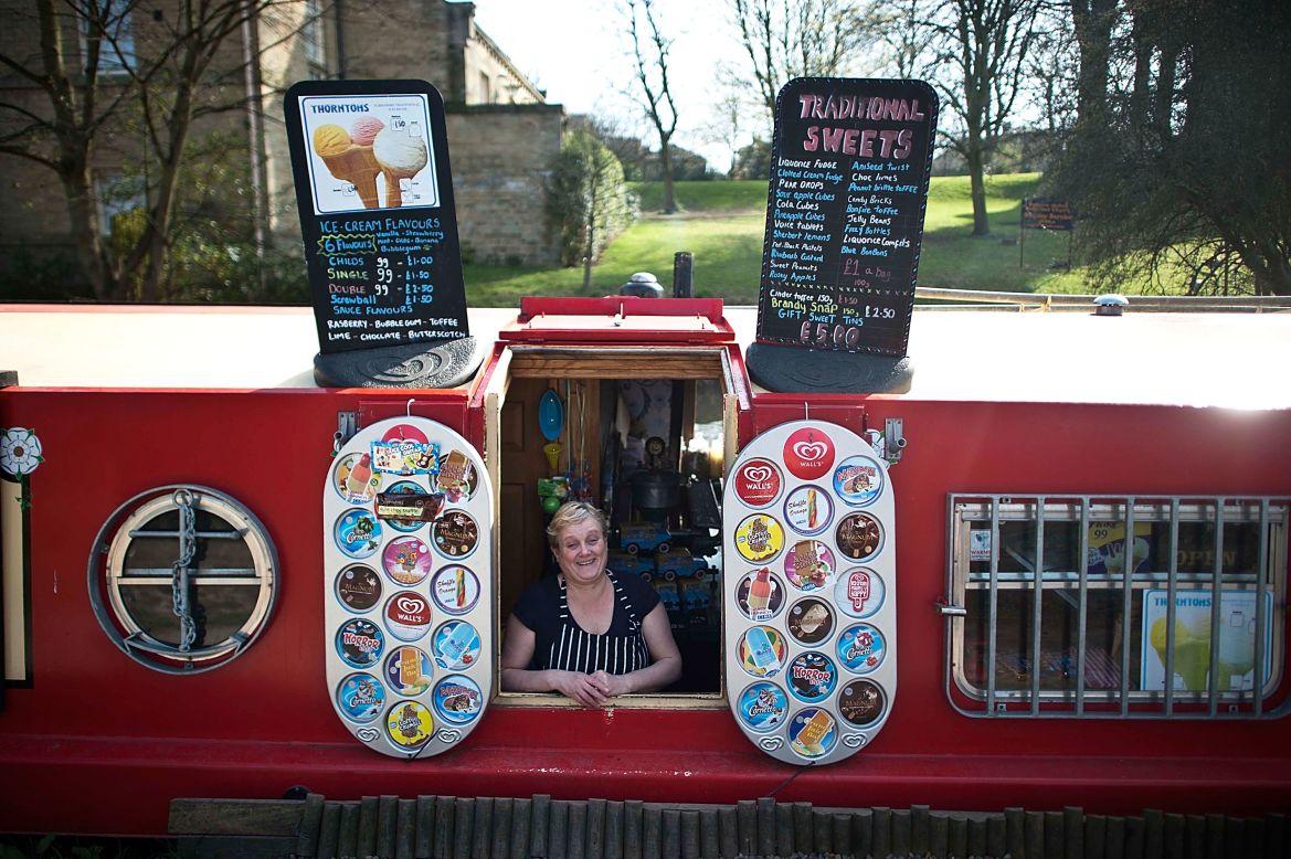 Las barcazas no solo ofrecen un hogar, sino una oportunidad única de vender al por menor, tal como lo muestra felizmente este vendedor británico de helados.