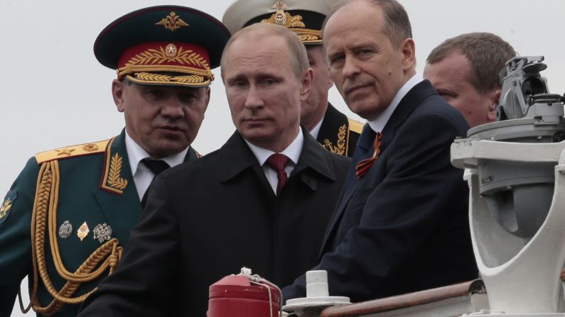 Russian President Vladimir Putin, flanked by Defense Minister Sergei Shoigu, left, and Federal Security Service Chief Alexander Bortnikov, right, arrives at a Victory Day celebration after inspecting battleships in Sevastopol.